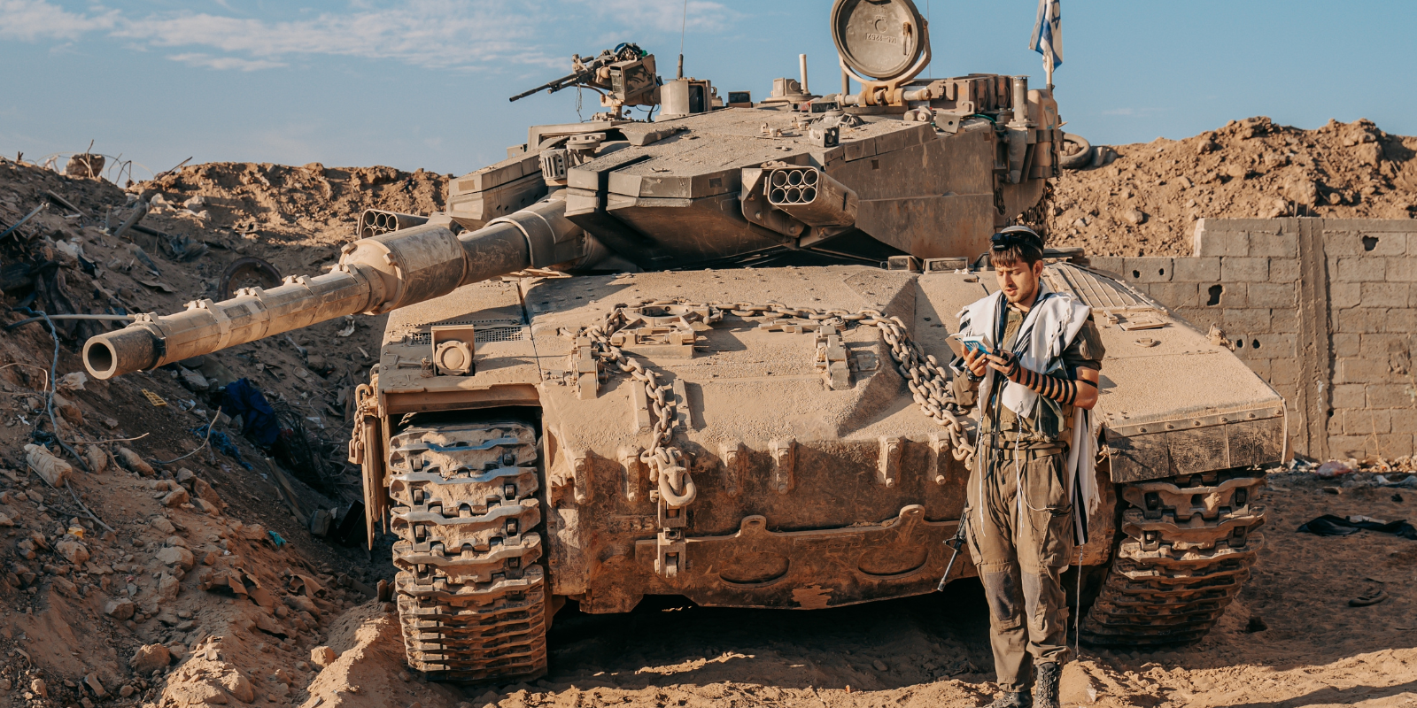 An IDF soldier in Gaza praying next to his tank (Shutterstock.com)