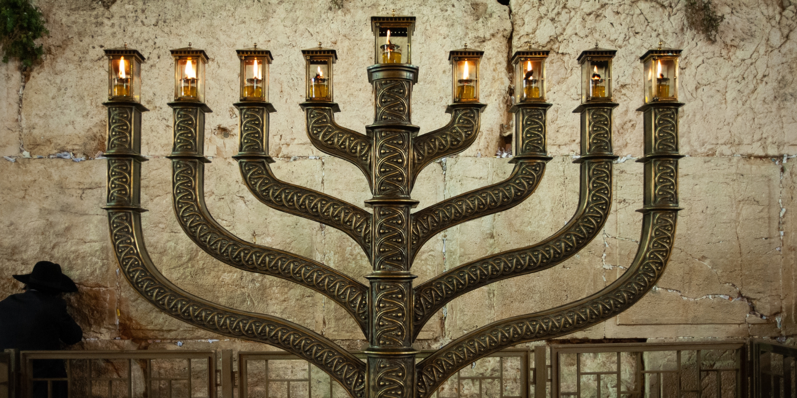 Eight candles burning in the Chanukah menorah at the Western Wall in Jerusalem (Shutterstock.com)