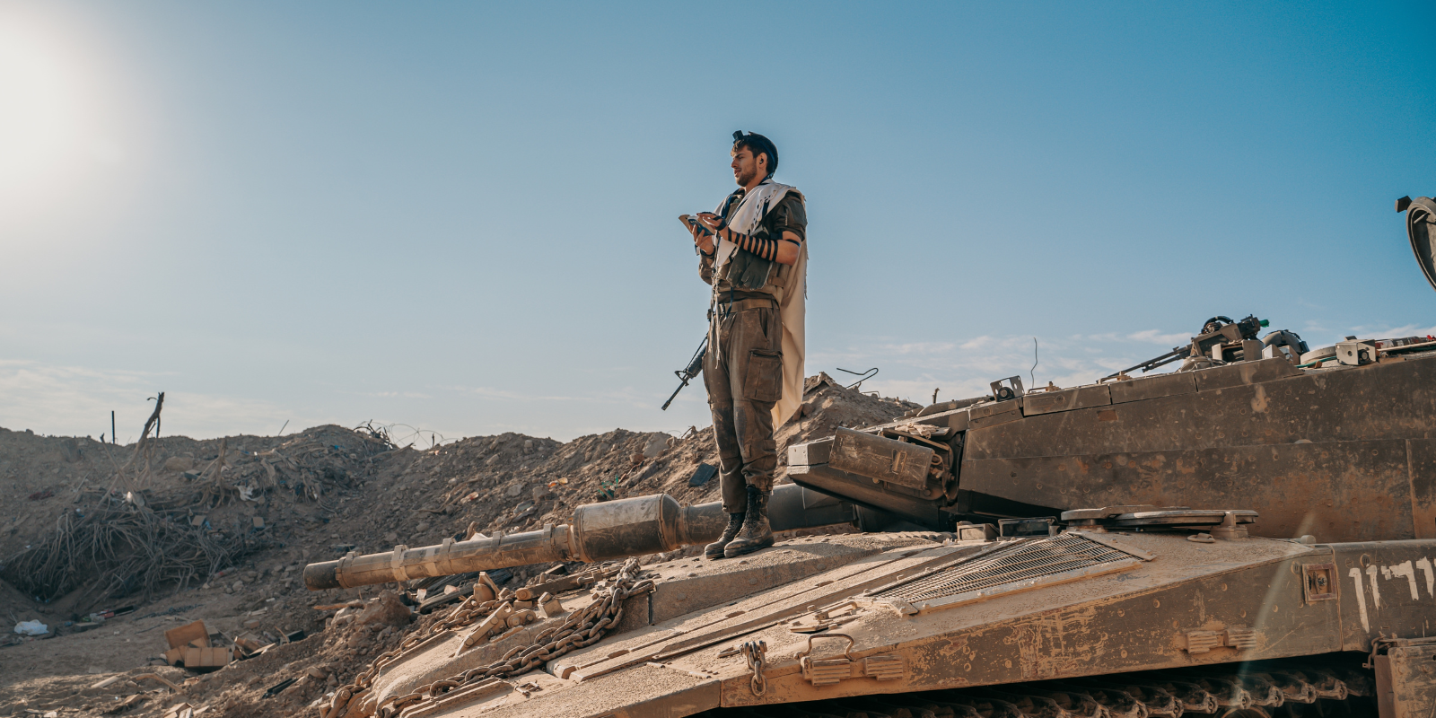 An IDF solider reciting the morning prayers wearing a prayer shawl and tefillin (Shutterstock)