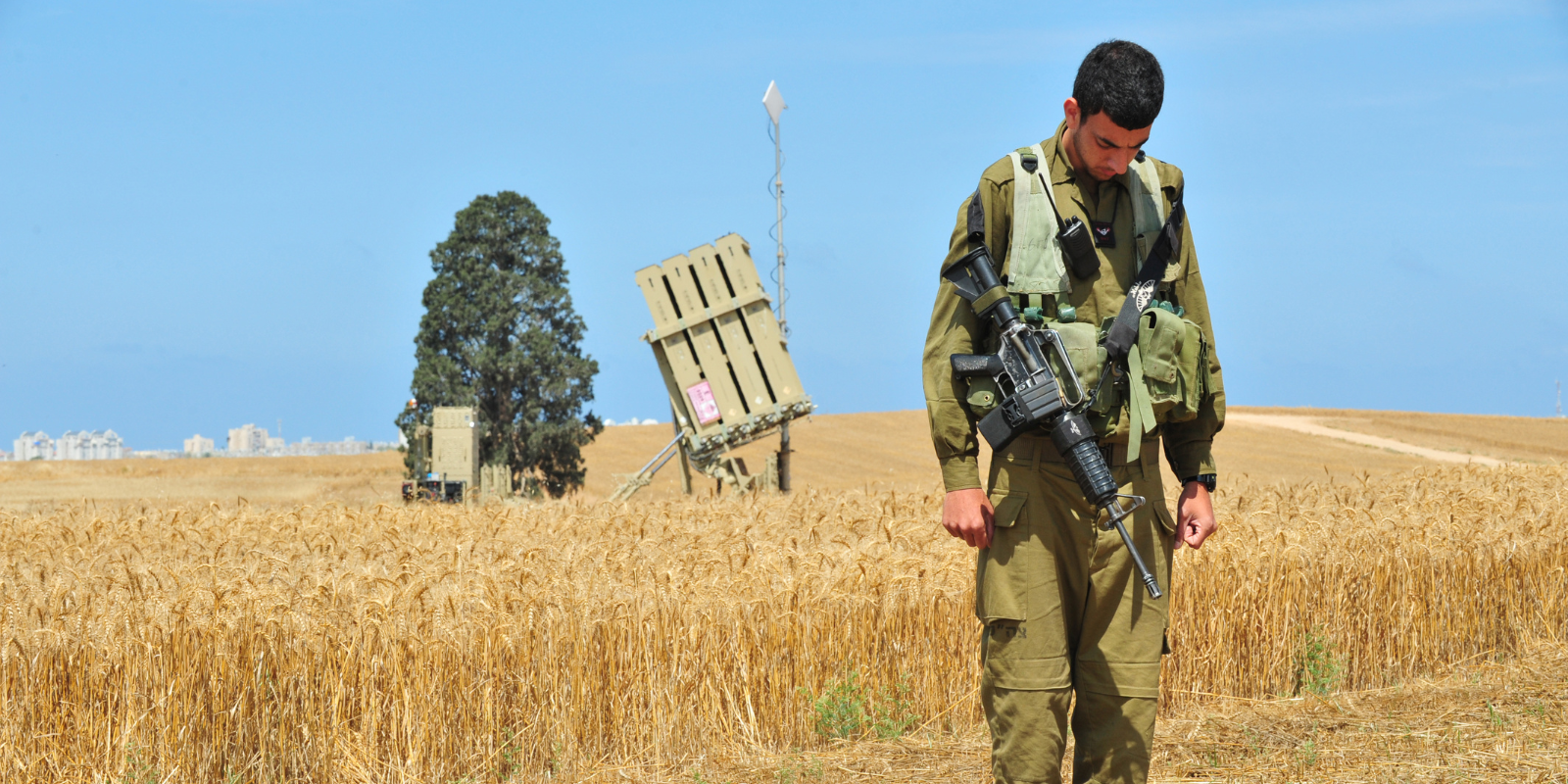 An Israeli soldier stands at attention to the sound of the siren in memory of the fallen on Israel's Memorial Day (ChameleonsEye, Shutterstock.com)