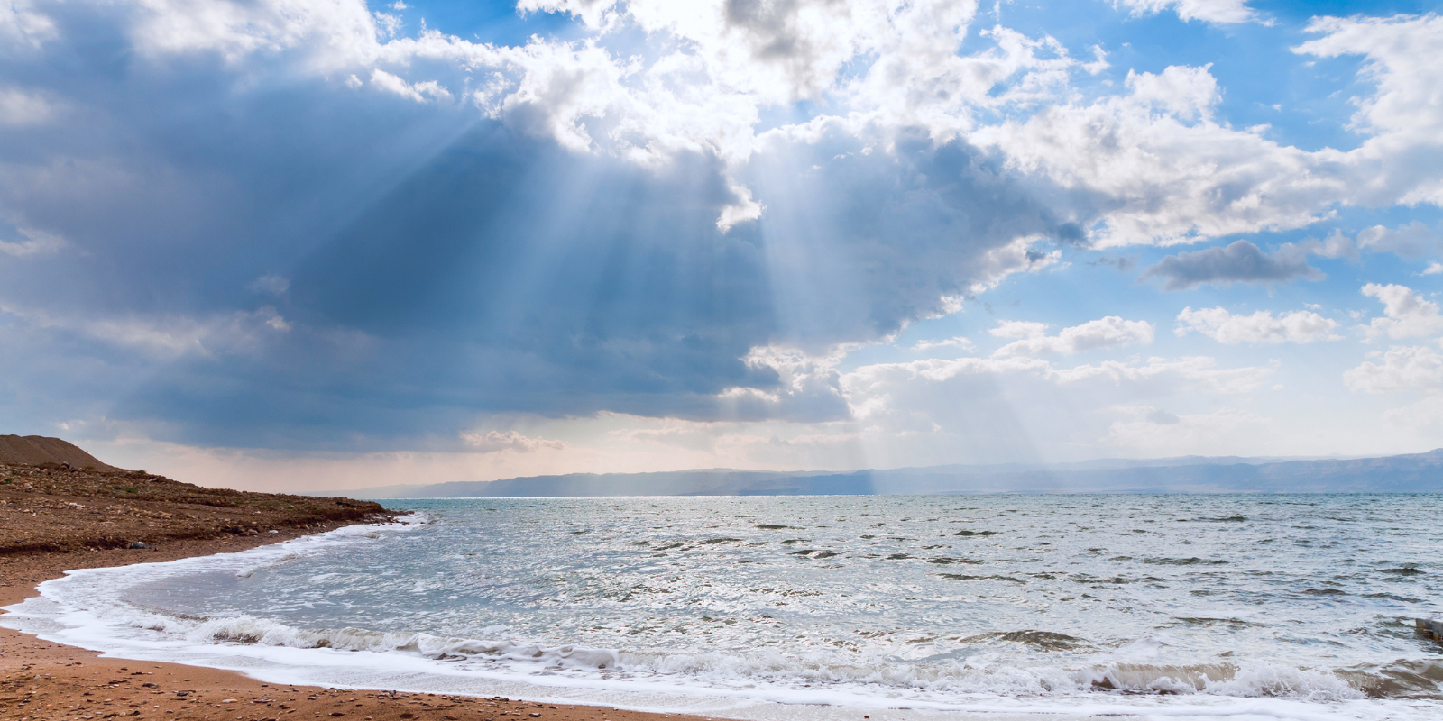 Sunbeams though dark blue clouds above the Dead Sea (vvoe, Shutterstock.com)