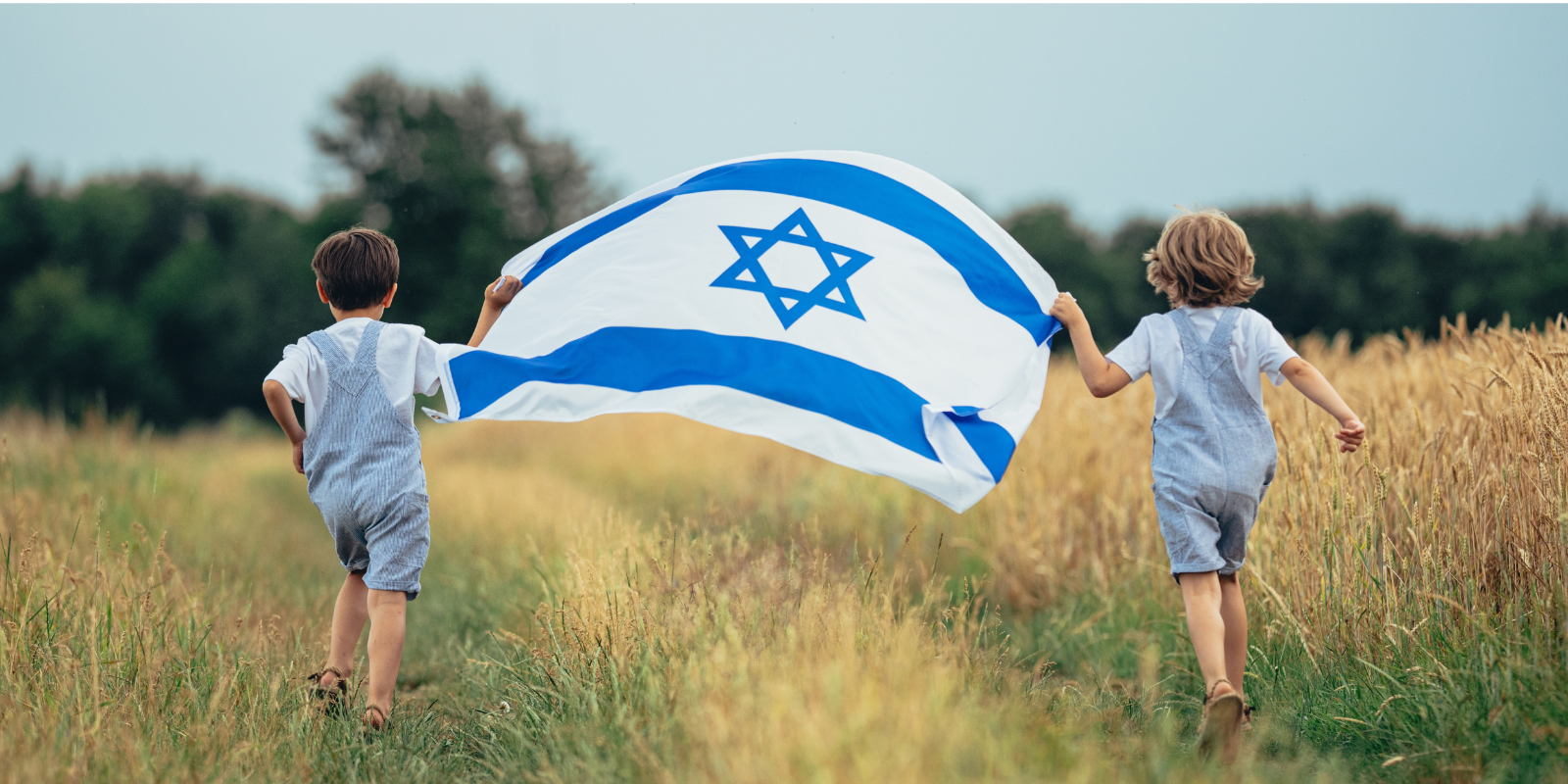 Two little Israeli boys run with the flag (Stock Holm, Shutterstock.com)